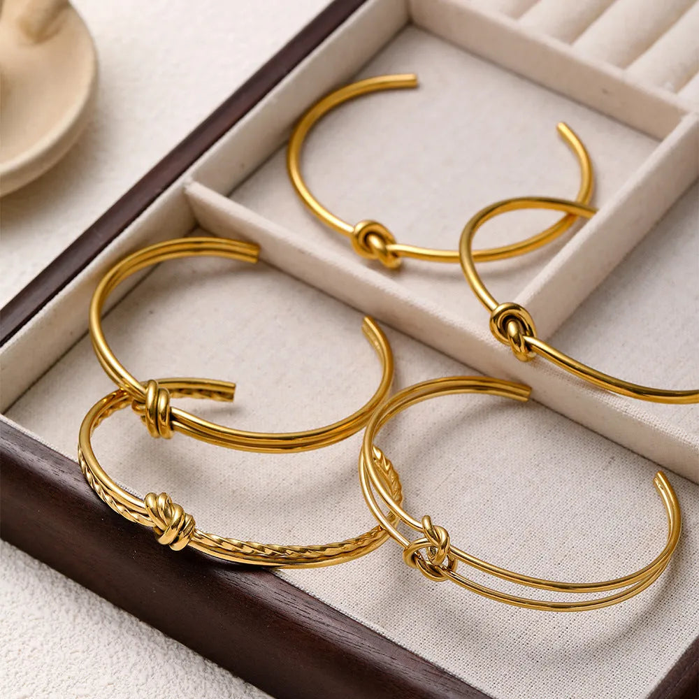 Adjustable open C-shaped double-layer bracelet in gold plating with a knotted design on stainless steel.