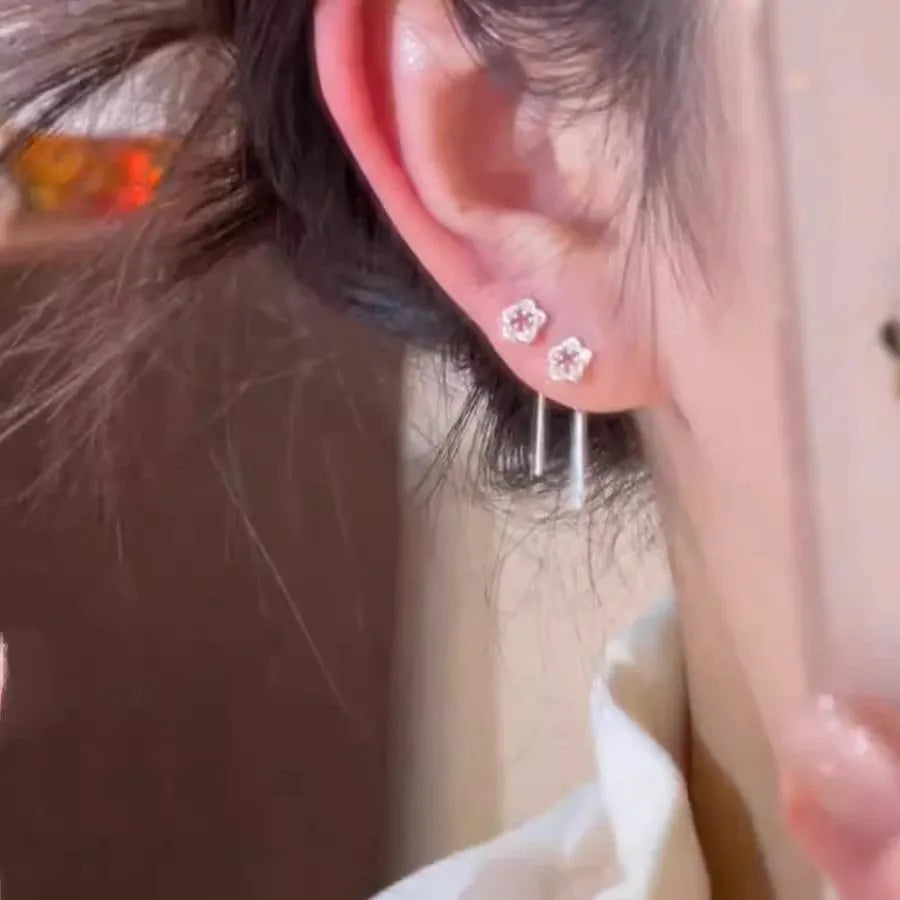 A pair of silver-coloured alloy drop earrings with a hollow floral petal design.