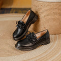 Black British style women's leather shoes with round toe and chunky flat heel on a white background.