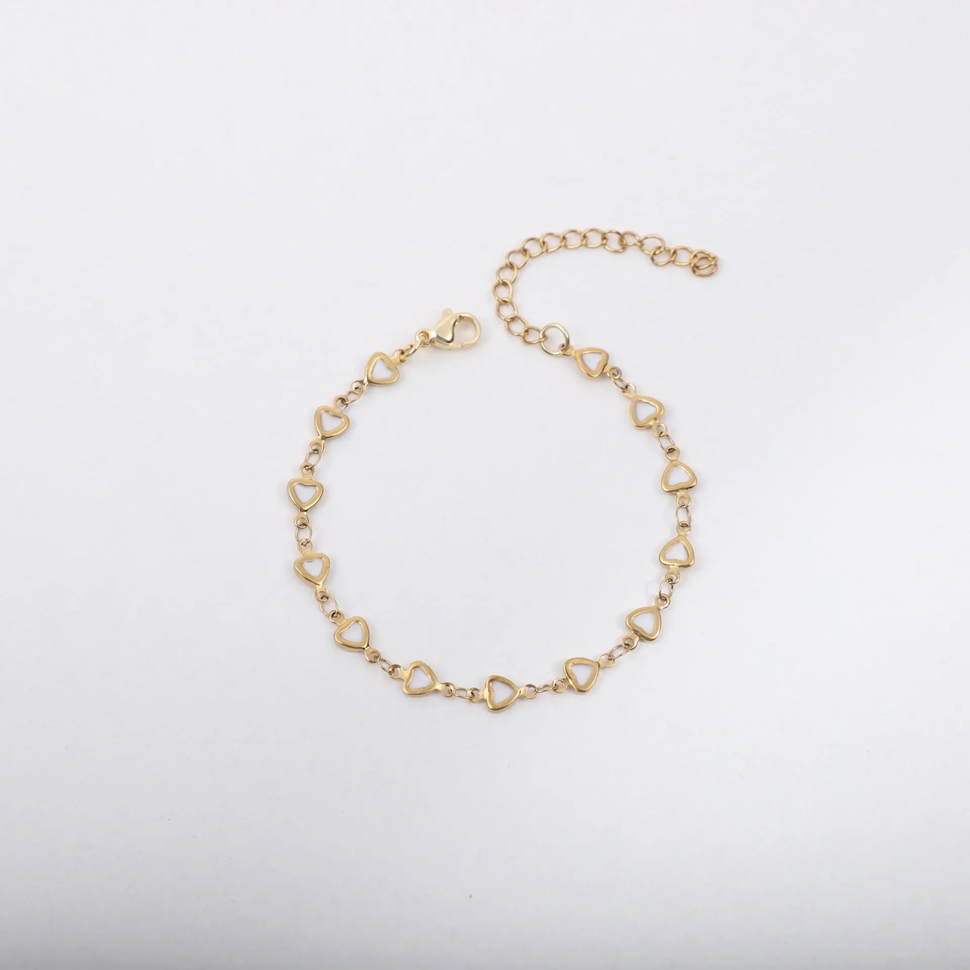 Stainless steel heart-shaped bracelet with a gold-plated finish on a wrist, showing the 17+5cm adjustable chain.
