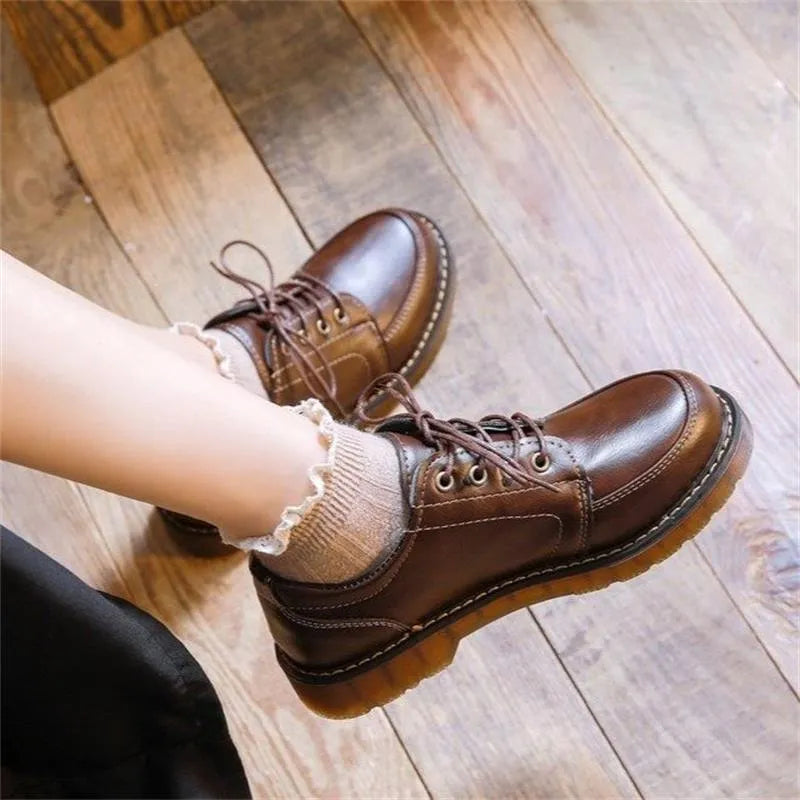 Women's preppy style brown retro Mary Jane pumps with round toe and front lace-up closure on a white background.