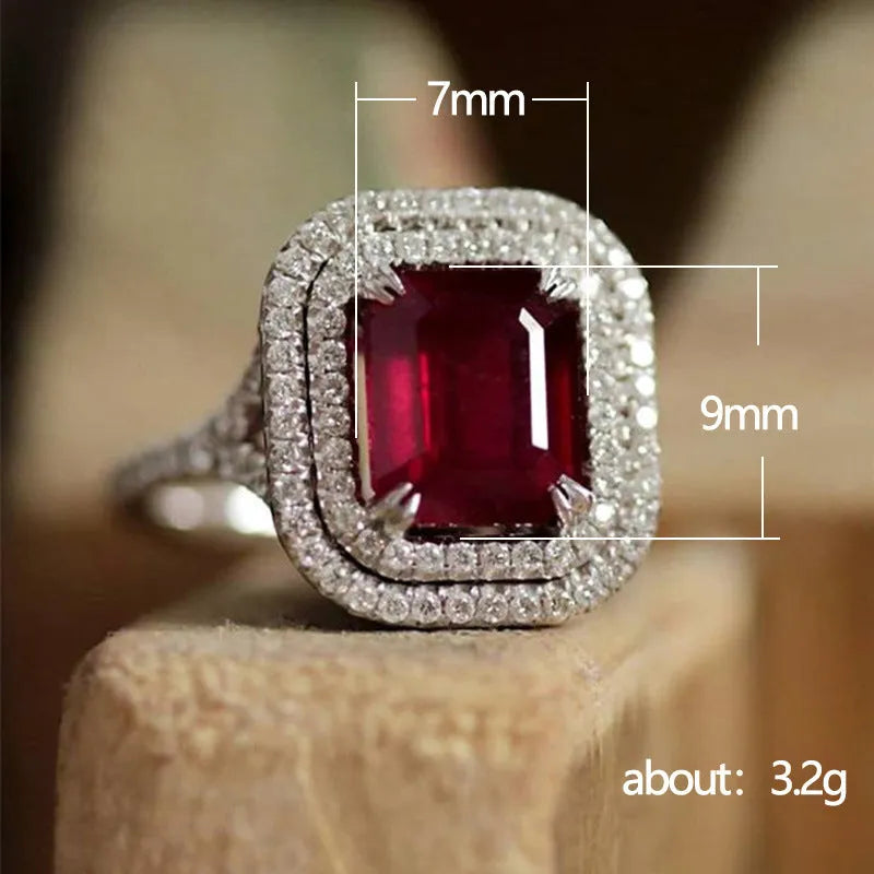 Red geometric square copper ring with clear princess-cut rhinestones, shown on a finger.
