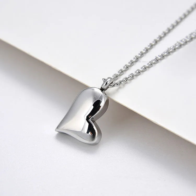 Curved peach heart silver stainless steel pendant necklace on display showing chain and pendant detail