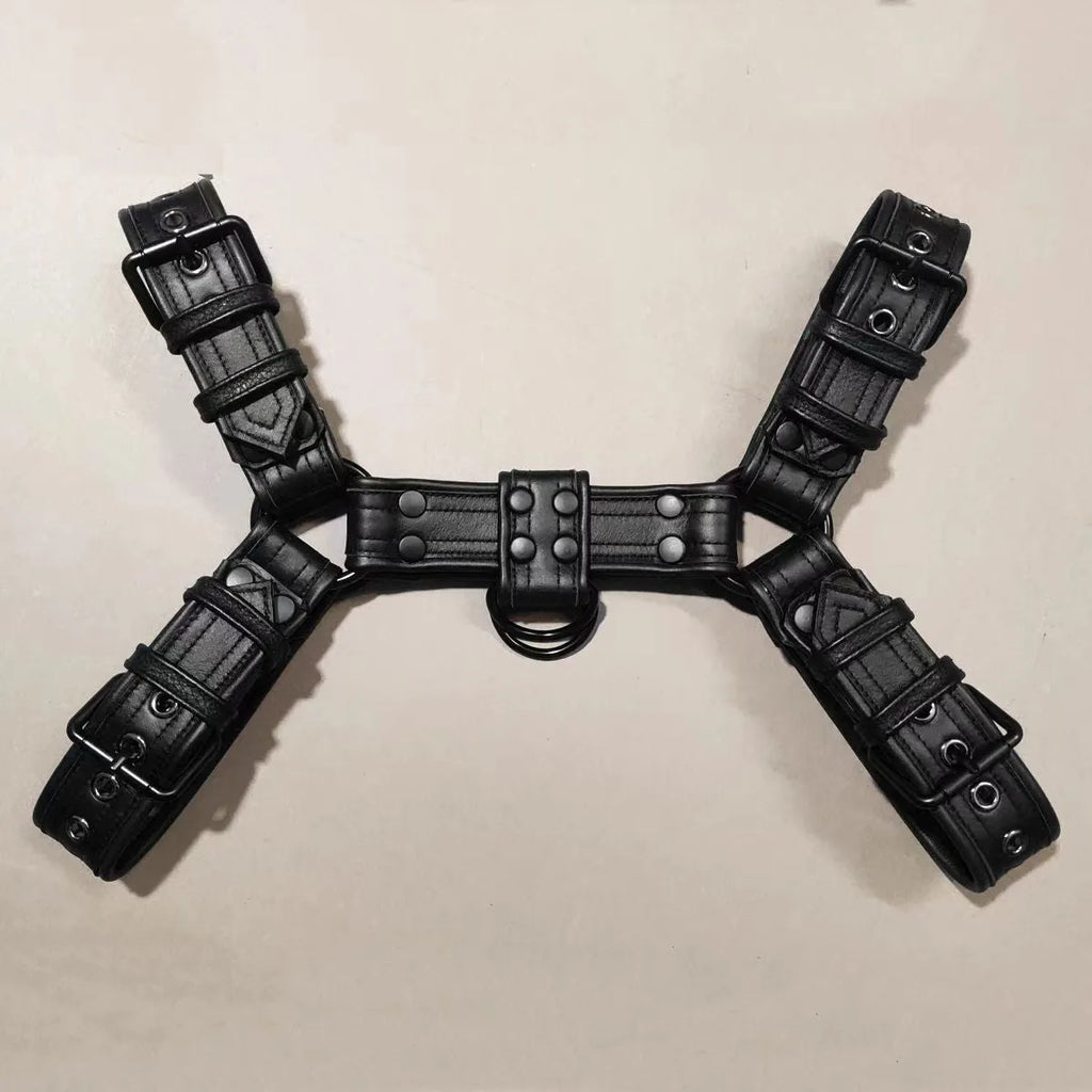 Black leather chest strap for men with metal buckle and rivet details on a mannequin.