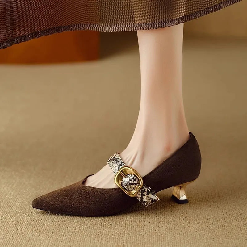 Black women's pointed toe stiletto heels with an ankle buckle fastening on a rubber sole.