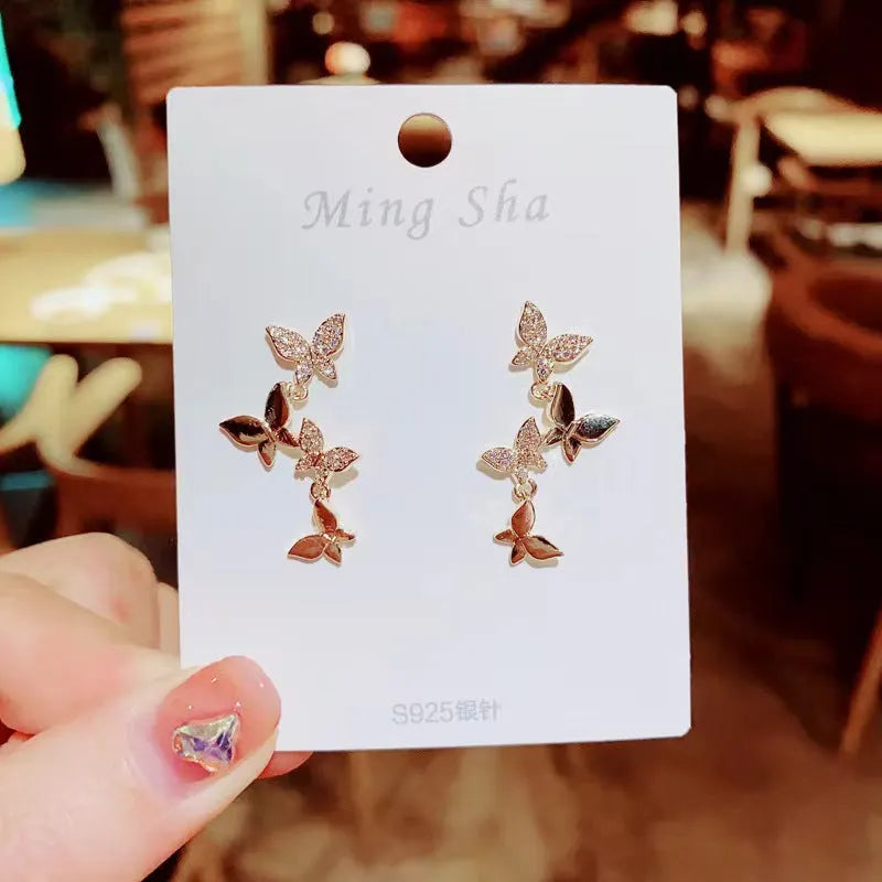 Women's butterfly copper earrings with gold-coloured drops and natural style design