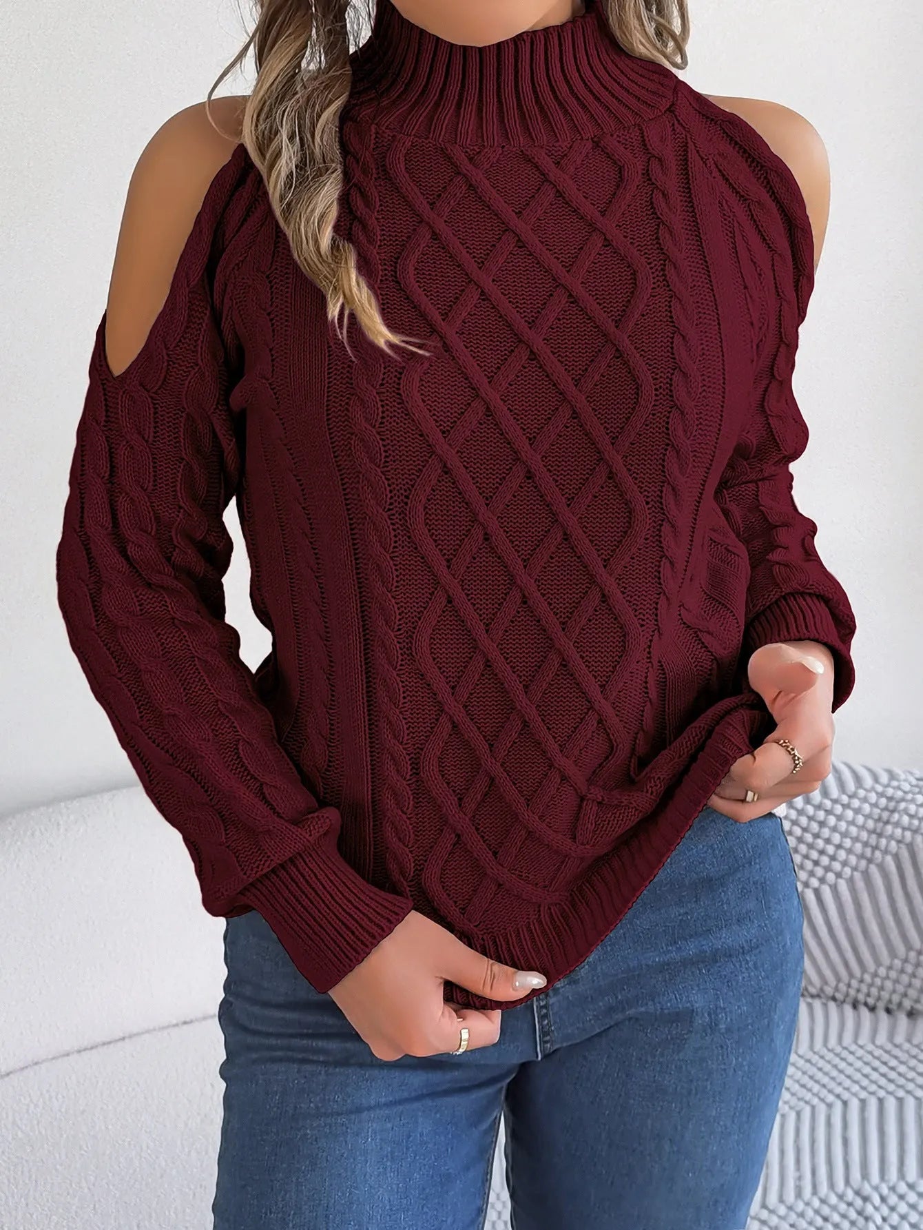 Gray women's acrylic sweater with a twisted knit pattern, half-high collar, and long lantern sleeves on a hanger.