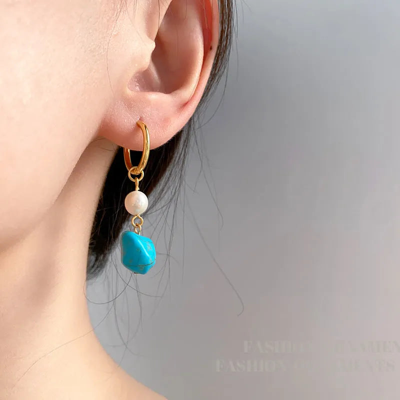 A pair of turquoise and cultured pearl clip-on earrings with irregular geometric copper shapes, showing both long and short styles.