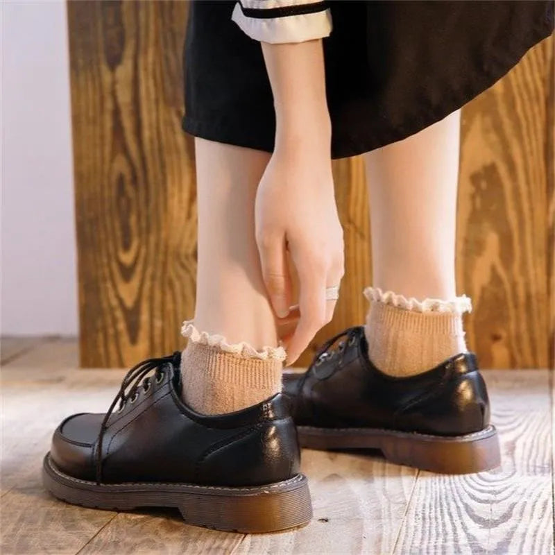 Women's preppy style brown retro Mary Jane pumps with round toe and front lace-up closure on a white background.