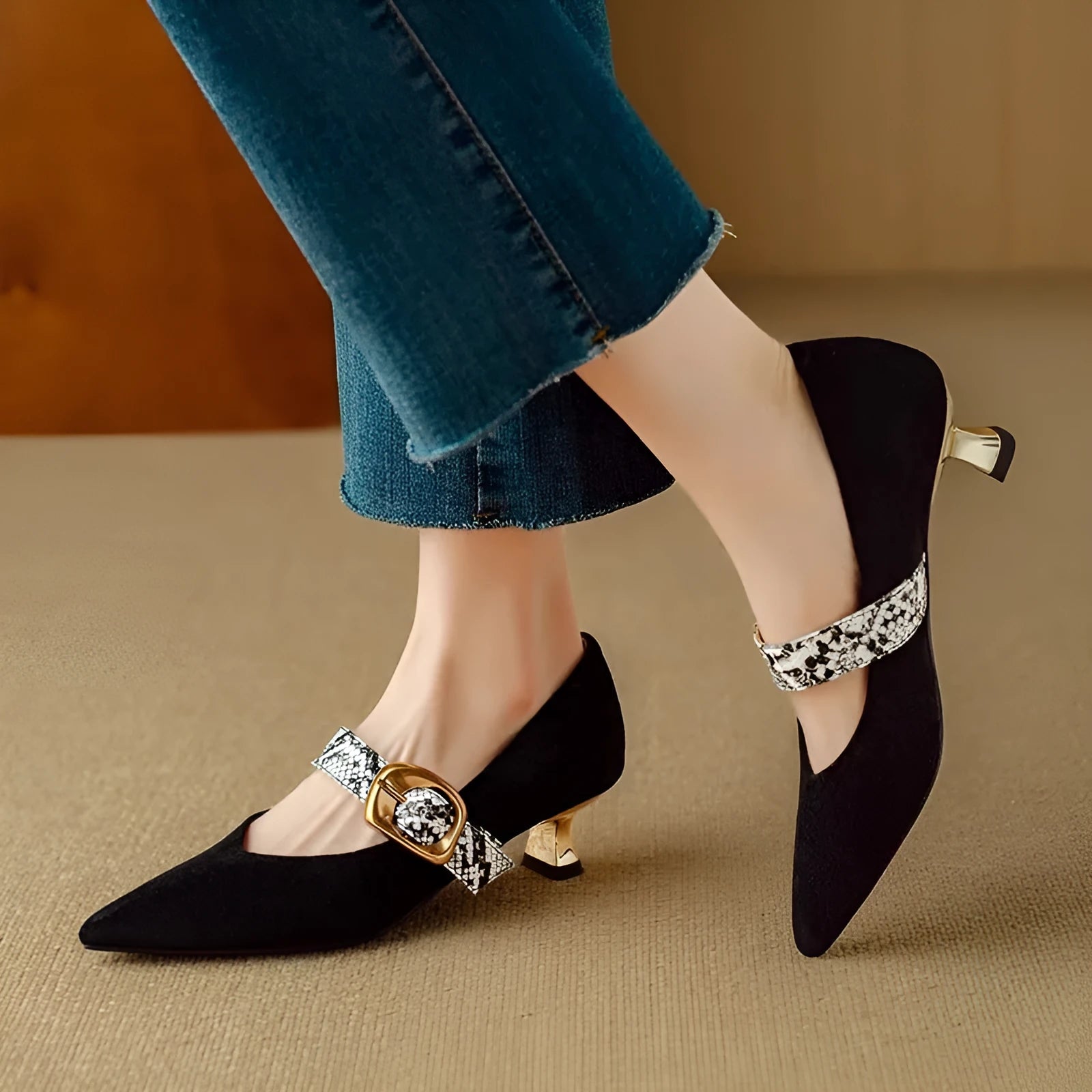 Black women's pointed toe stiletto heels with an ankle buckle fastening on a rubber sole.