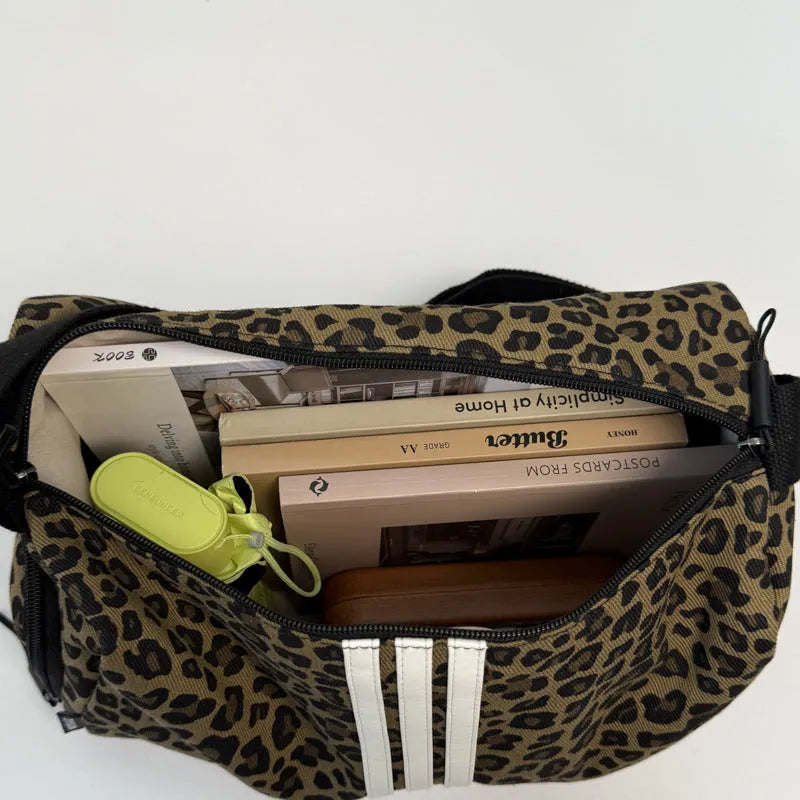 Cloth messenger bag with leopard print pattern showing cross-body strap and stitching details