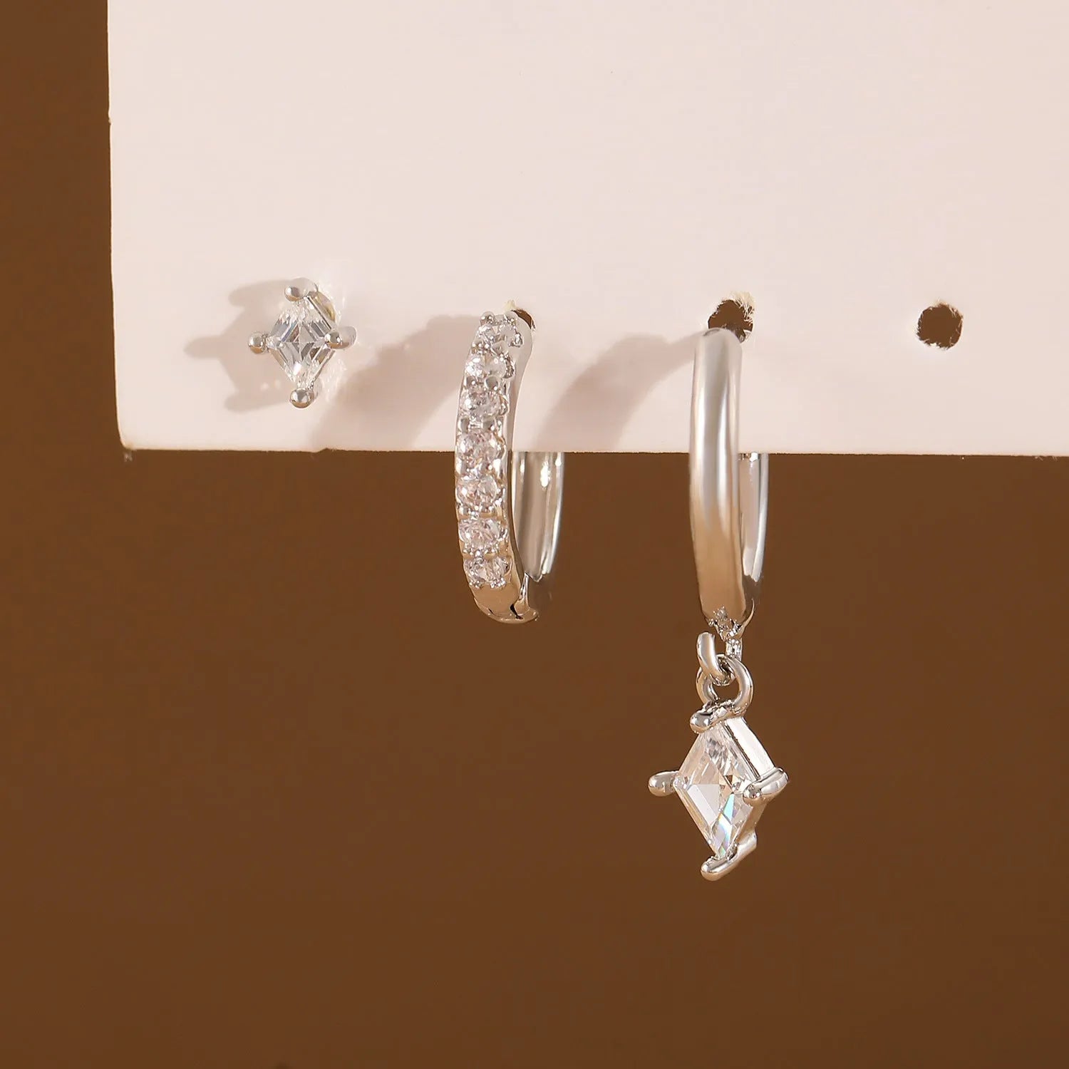 Geometric zircon earring three-piece set showing ear ring, stud, and clasp in gold and silver colours