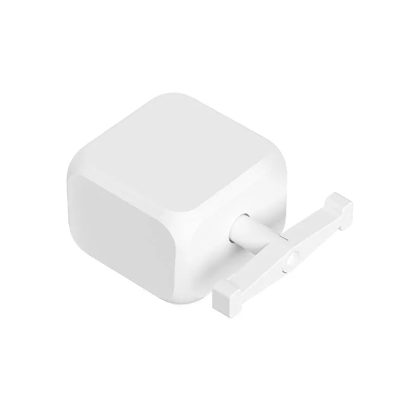 Small white Bluetooth rocker arm remote control on a surface, showing its compact size.