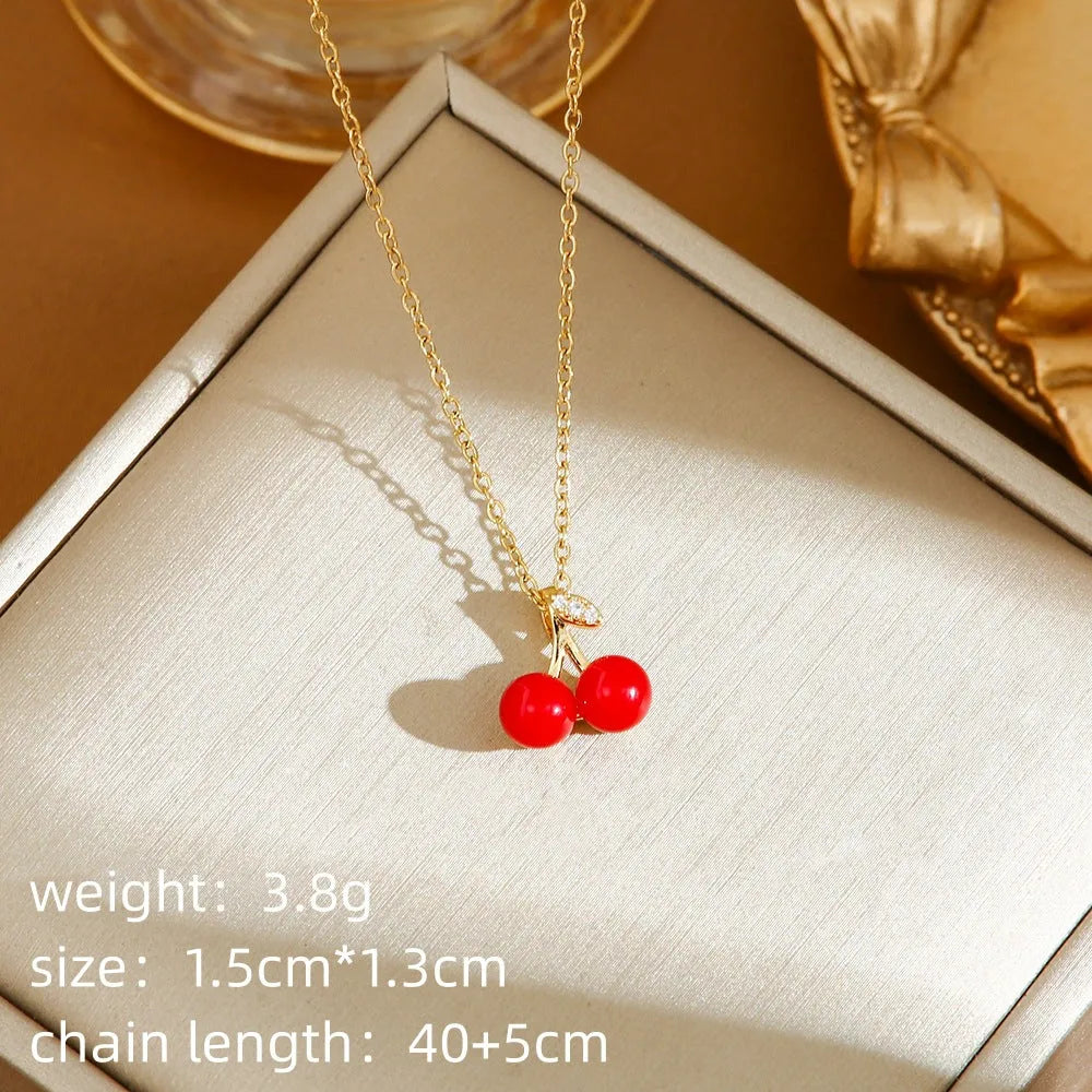 Titanium steel necklace with O-ring chain and a delicate cherry pendant in a gold-tone finish.