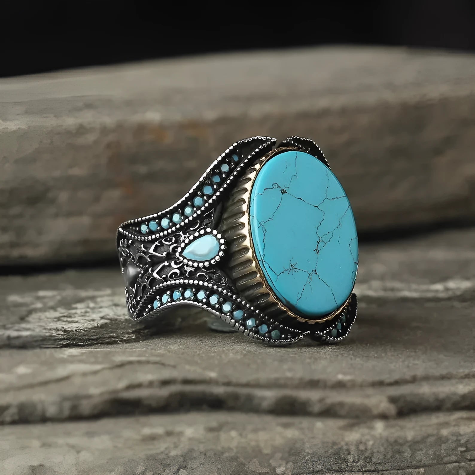 Men's antique silver alloy ring with a turquoise-coloured centre on a finger, showing its simple round design.