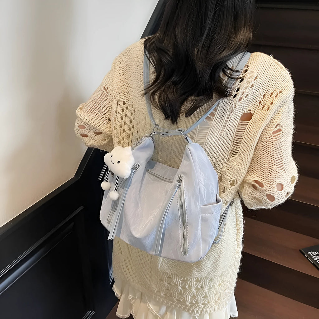 Soft PU women's fashion backpack in blue colour with a matching pendant.