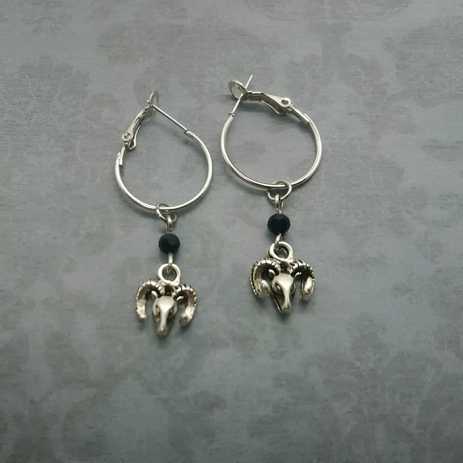 Silver alloy women's earrings with round ring design and Tibetan antelope motif.