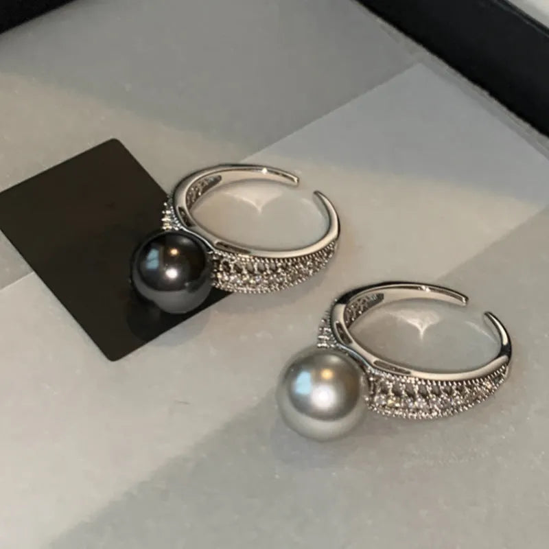 Geometric black pearl open finger ring with adjustable copper construction on female hand