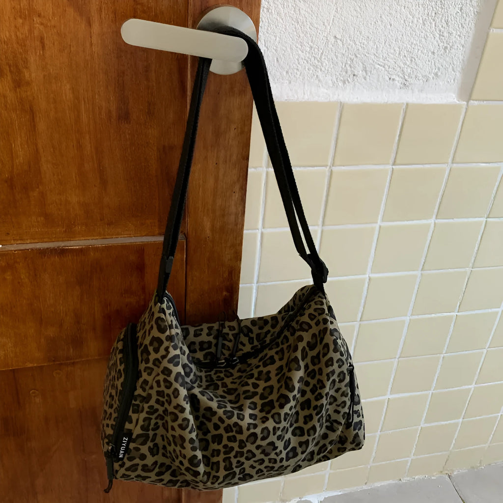 Cloth messenger bag with leopard print pattern showing cross-body strap and stitching details