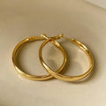 A pair of circular metal earrings with a gold electroplated finish, measuring 40mm.