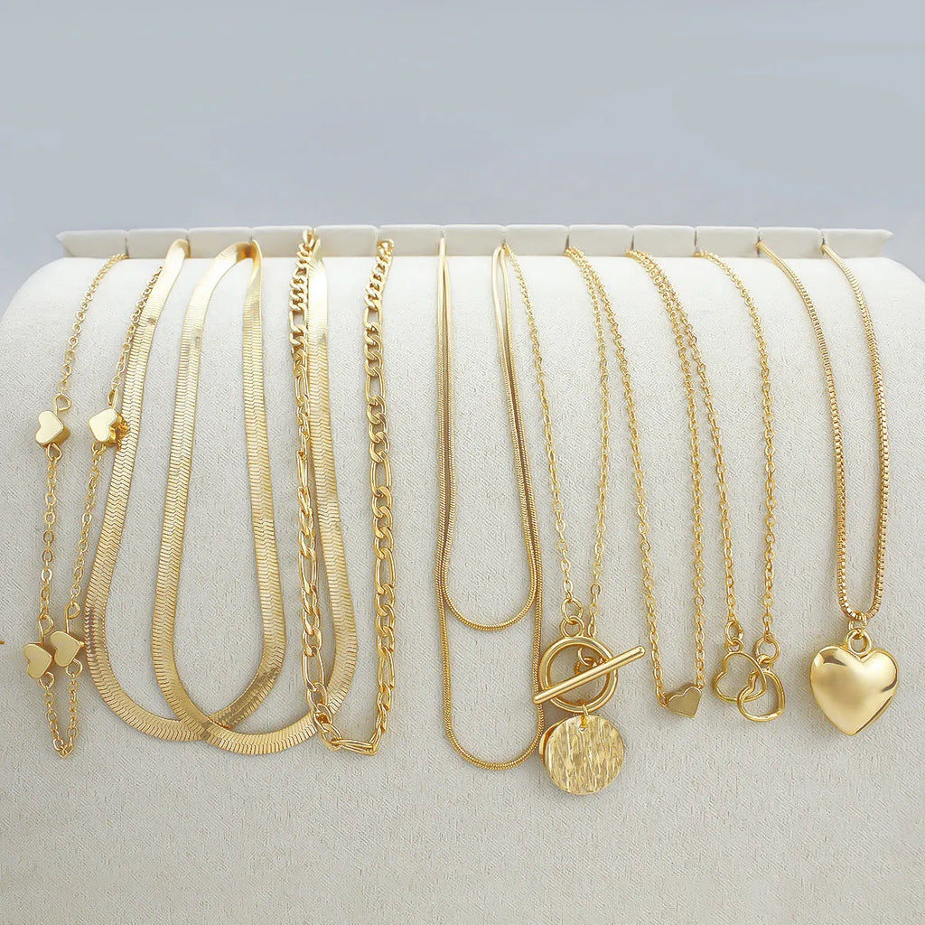 Set of 10 gold electroplated necklaces with alloy pendants on snake bone chains