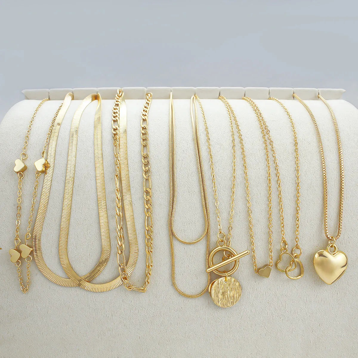 Set of 10 gold electroplated necklaces with alloy pendants on snake bone chains