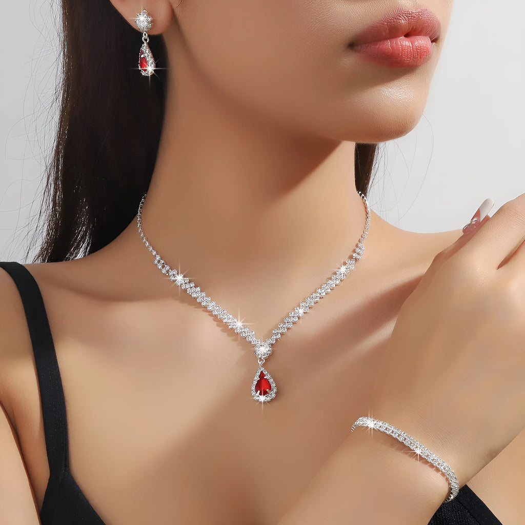 Women's claw chain necklace and drop rhinestone earrings set in blue on a white background.
