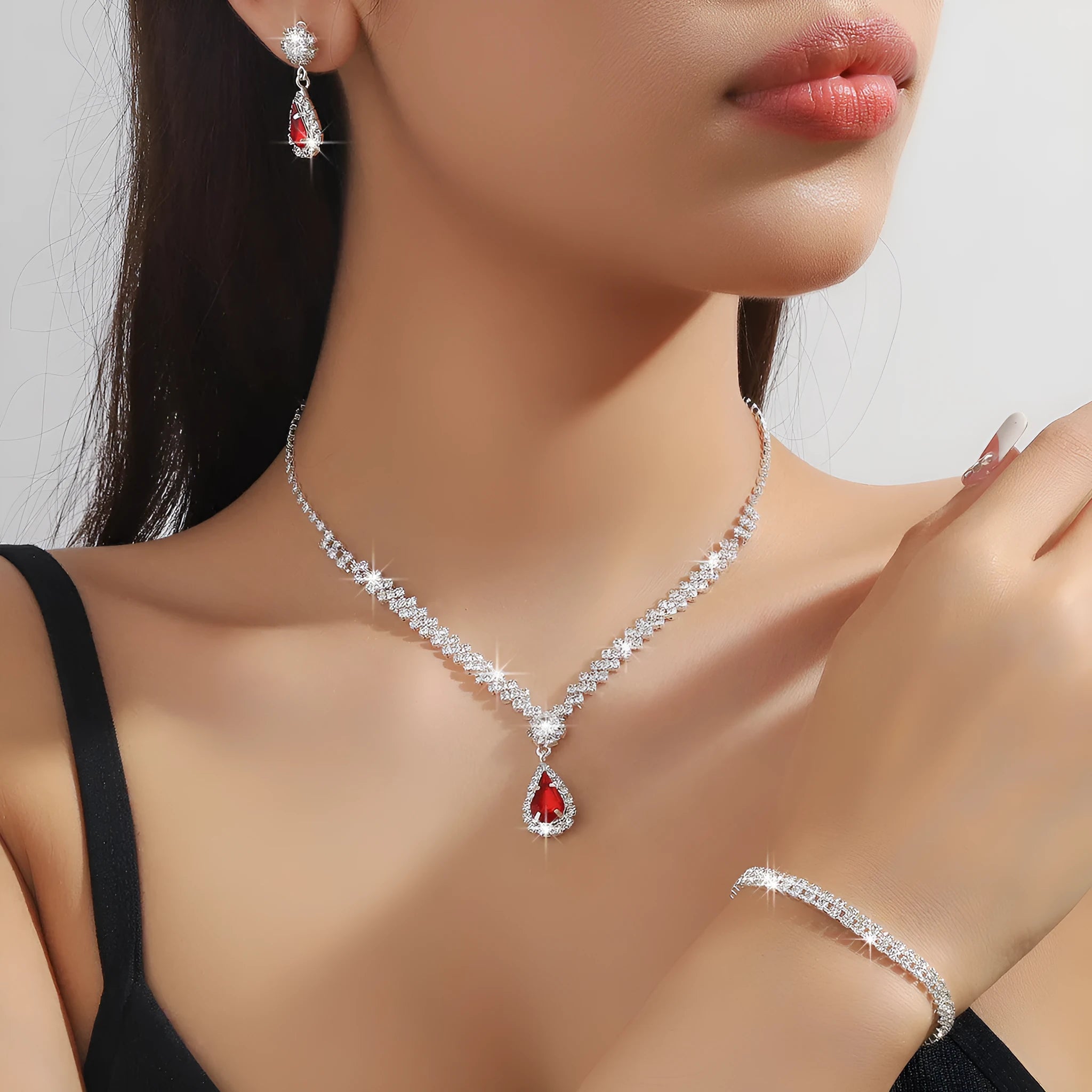 Women's claw chain necklace and drop rhinestone earrings set in blue on a white background.
