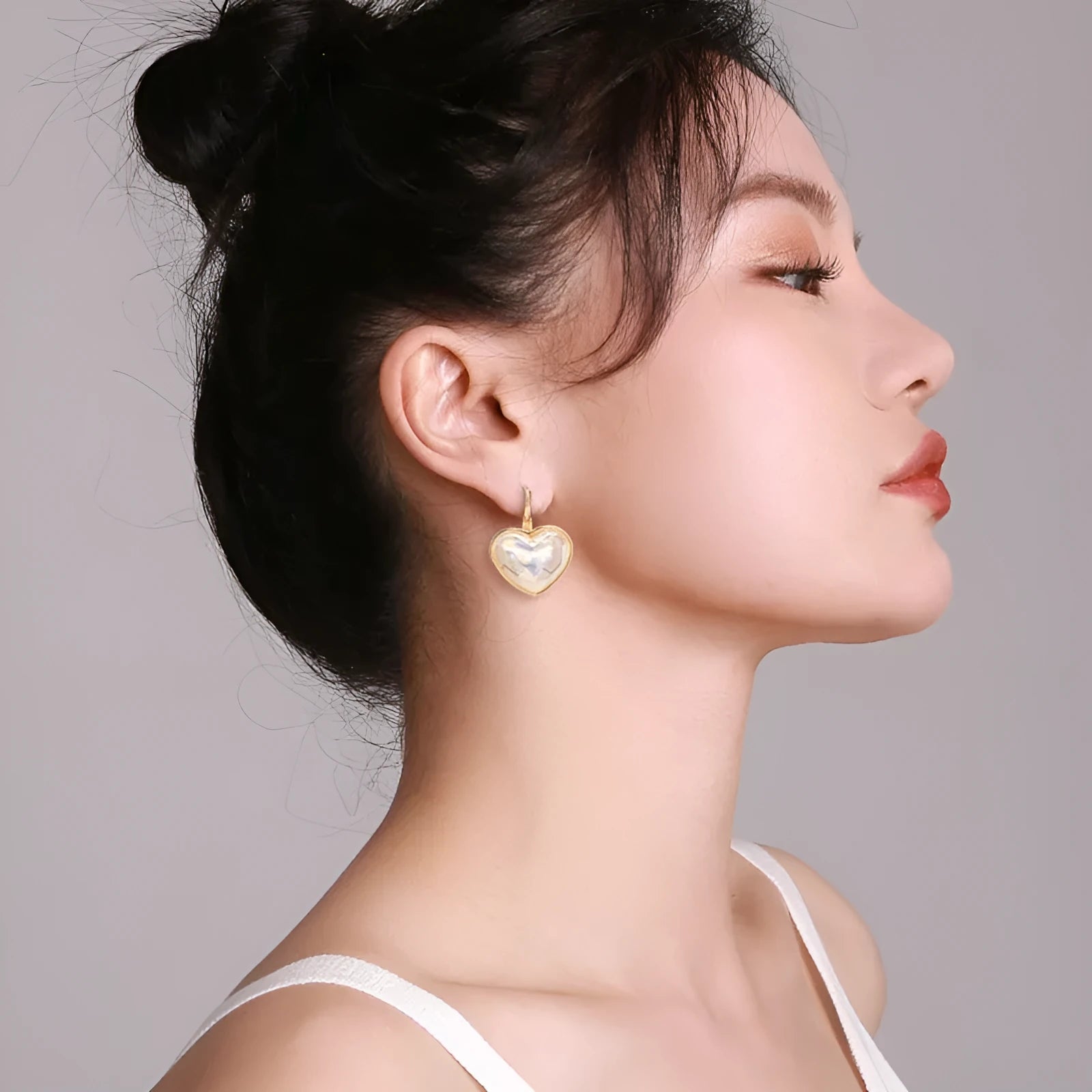 A pair of gold-coloured minimalist alloy ear clip earrings for women on a plain background.