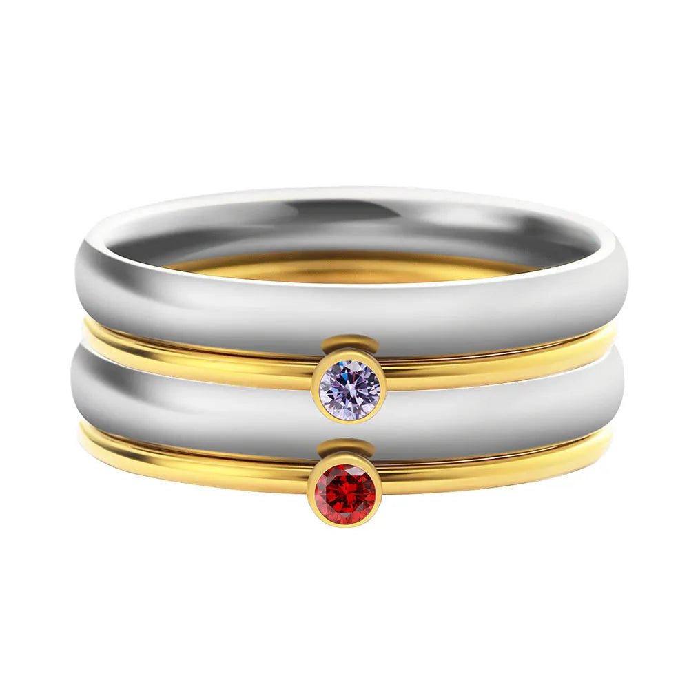 Geometric titanium steel ring with engraved design in December birthstone colour on a finger.