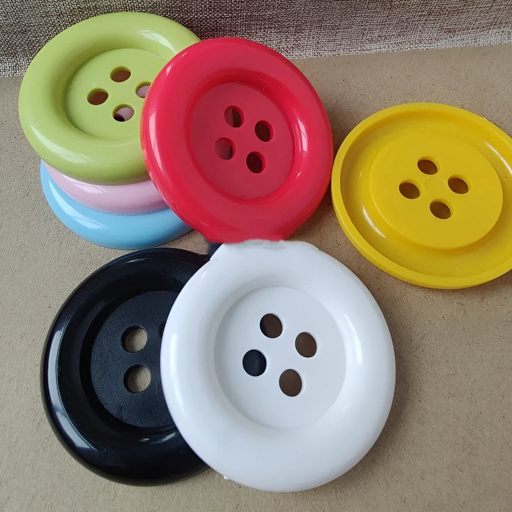 Large round plastic nylon buttons in multiple colours with four sewing holes for garment repair