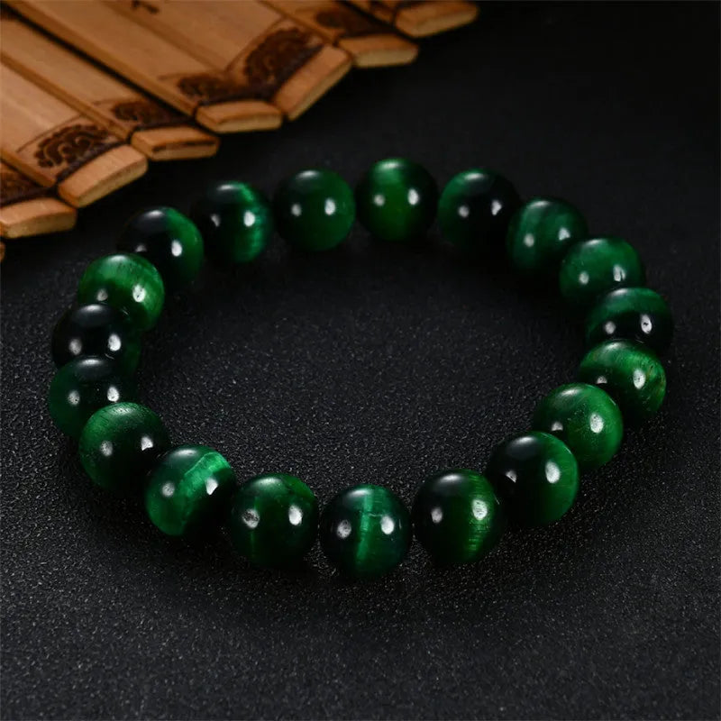 Polished green tiger eye stone bracelet with geometric beads on a wrist, showing size options.