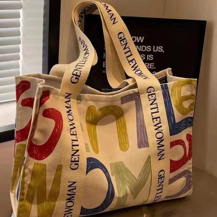 Large canvas tote bag with printed design options including letters and patterns.