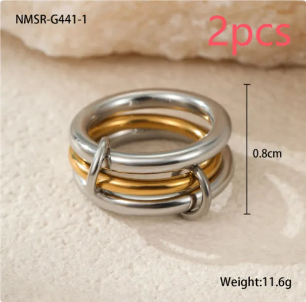 Stacked stainless steel rings with gold plating in coordinated colours showing layered hand jewellery design