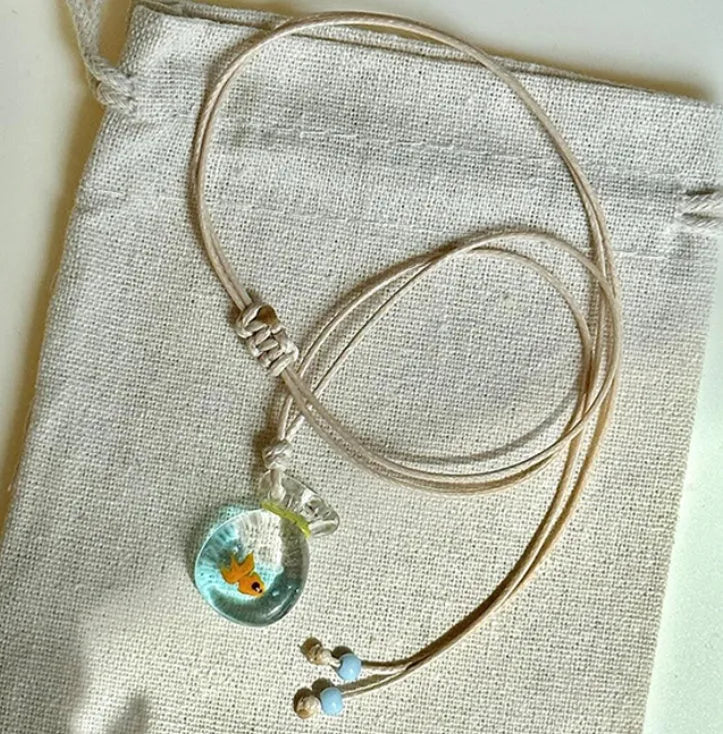 Women's coloured glaze small fish lucky bag pendant on a cotton linen clavicle chain necklace.