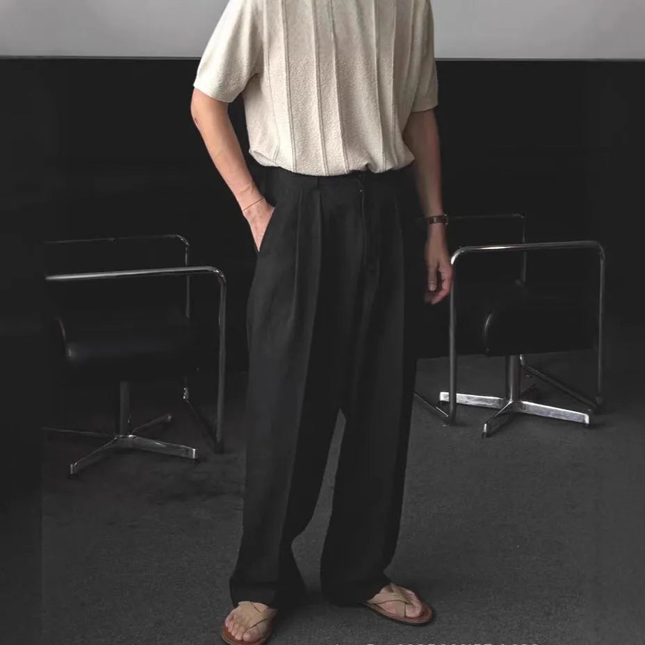 Man wearing apricot wide-leg cotton linen trousers with a mid waist and zip fly.