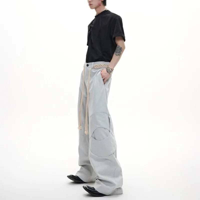 Men's dark blue cotton straight-leg jeans with loose fit, showing heavy 3D cutting, belt stitching, and decorative zip details.