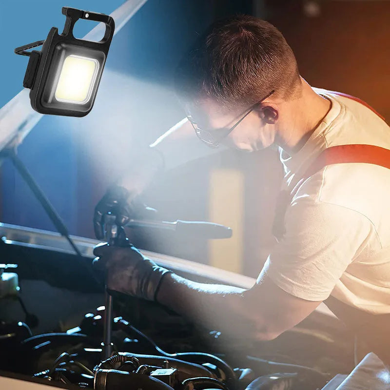 Black aluminium alloy USB rechargeable keychain torch with magnetic base and foldable handle.