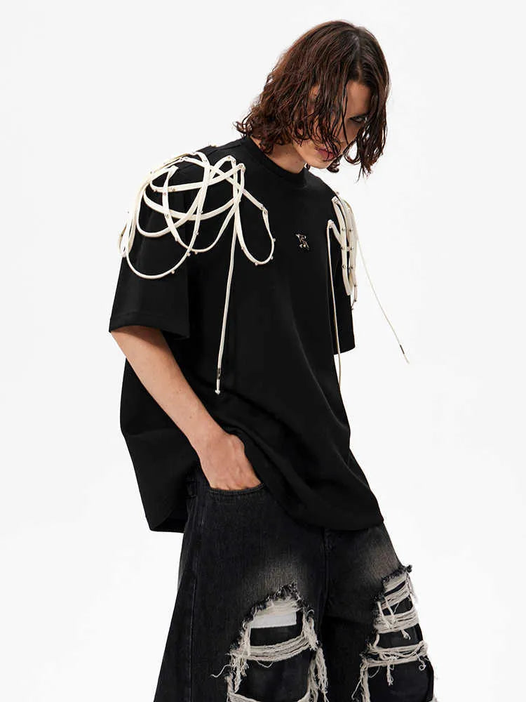 Black loose fit T-shirt with padded shoulders featuring decorative rivet detailing and ribbed texture