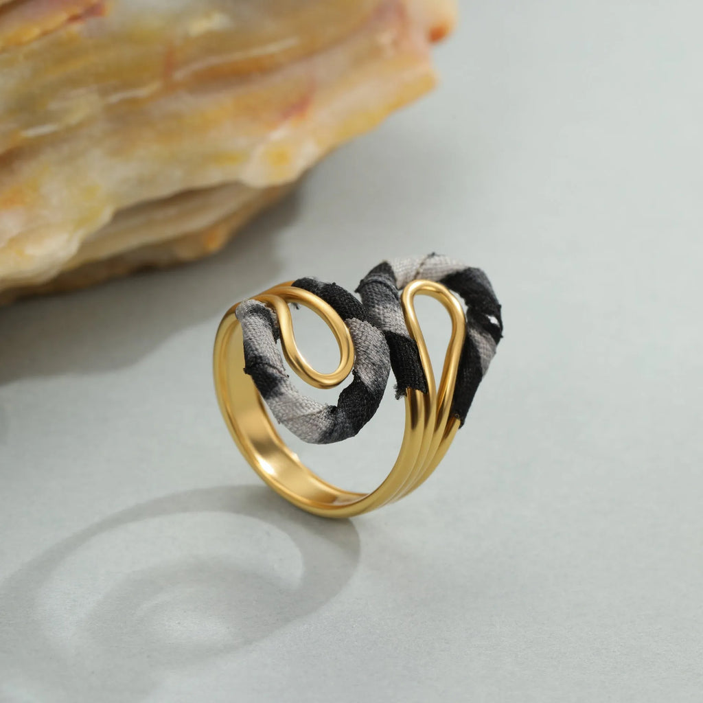 Leopard print geometric open mouth ring on a finger, showing heart shape and adjustable stainless steel band.