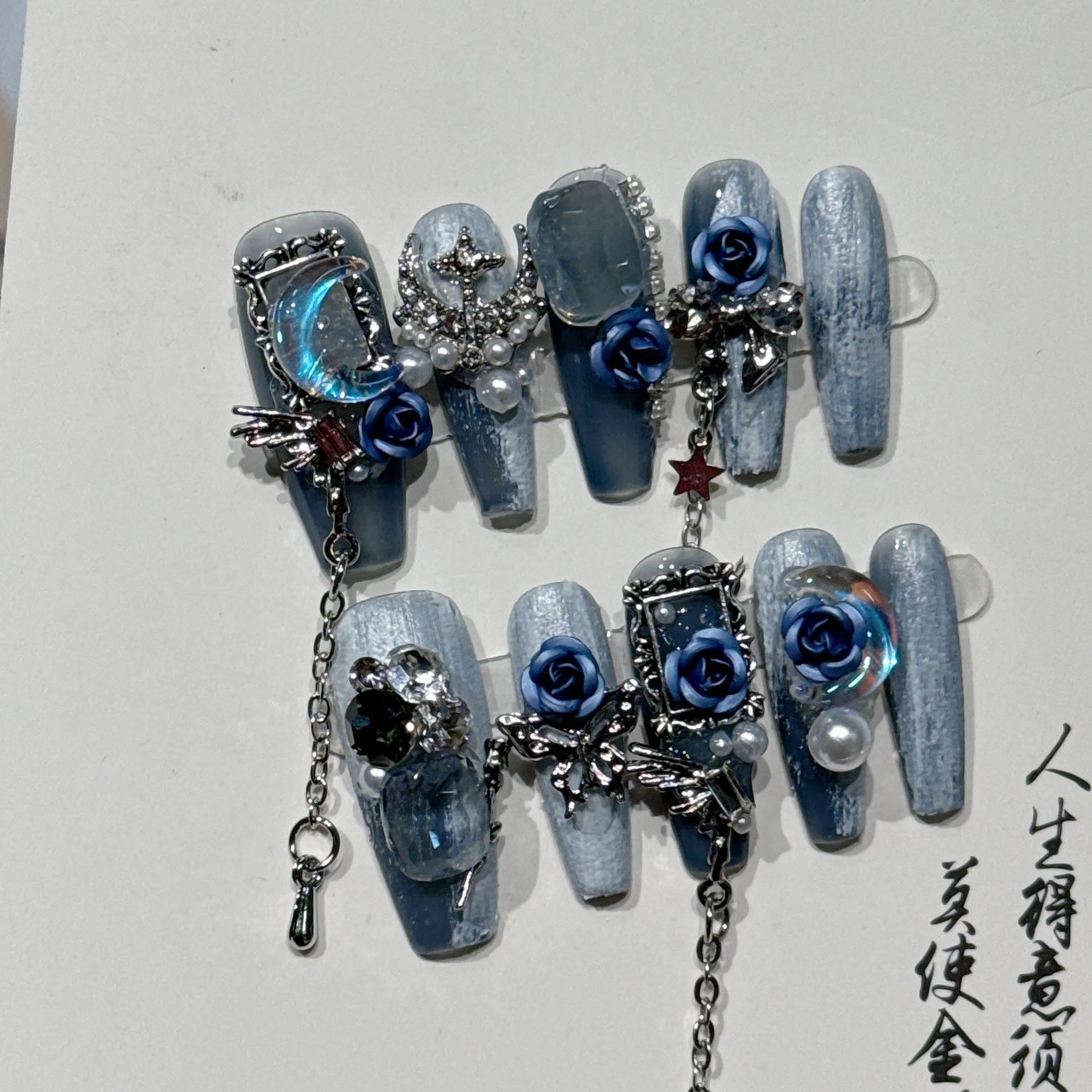 Heavy industry night blue false nails with ornate twinkling rose and tulip flower pattern.