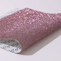 Sheet of rhinestones in an eight-eye pattern on a glue net backing, showing multiple colour options.