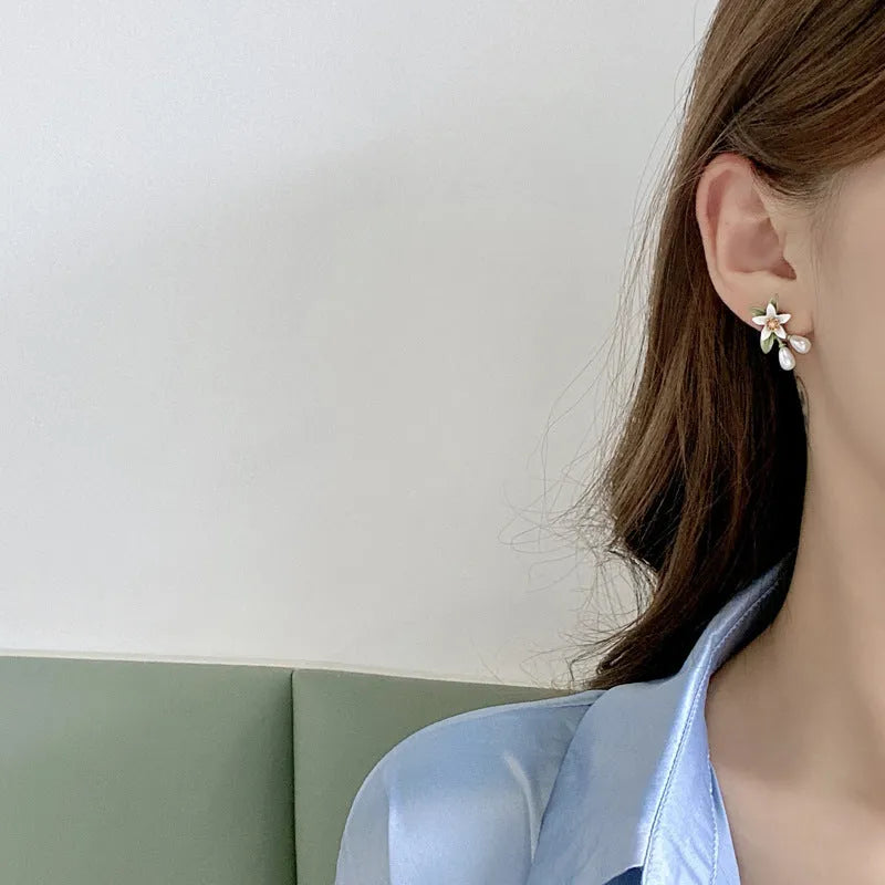 A pair of alloy flower earrings for women, shown in sterling silver needle flowers and flower ear clip styles.