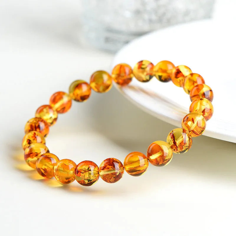 Natural yellow piebald amber beaded bracelet with geometric polished beads on a white background.