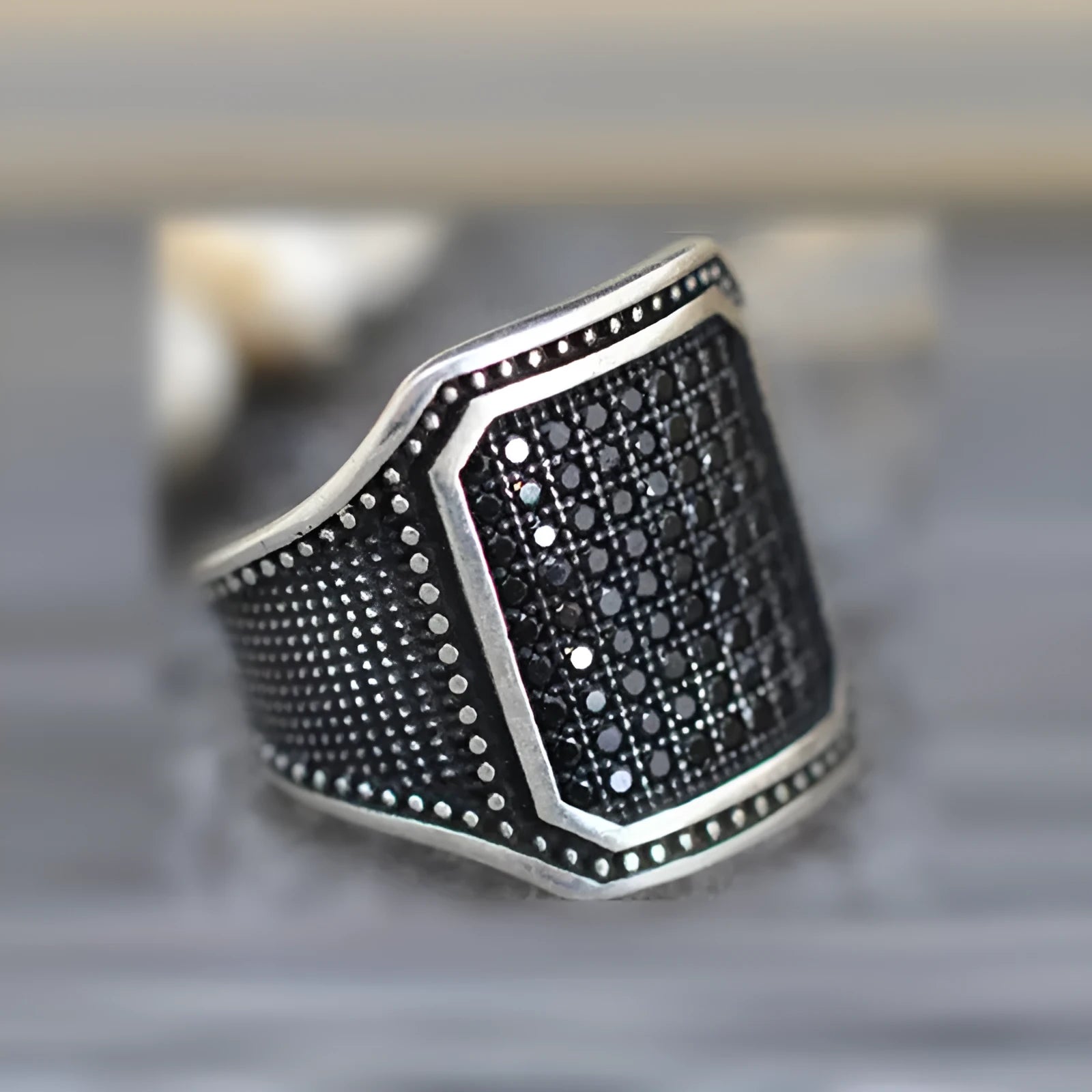 Black alloy ring with copper inlay detailing and a central zircon stone.