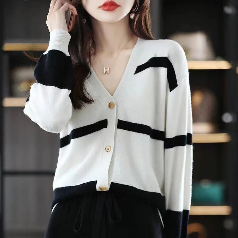 Woman wearing a slim fit V-neck knitted cardigan with a black and white 3D striped pattern