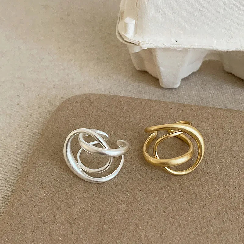 Gold and silver matte metal open rings with three-dimensional interlaced geometric design