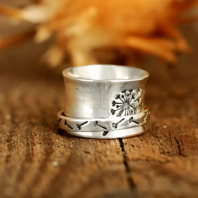 Silver rotatable flower ring on hand showing spinning floral design