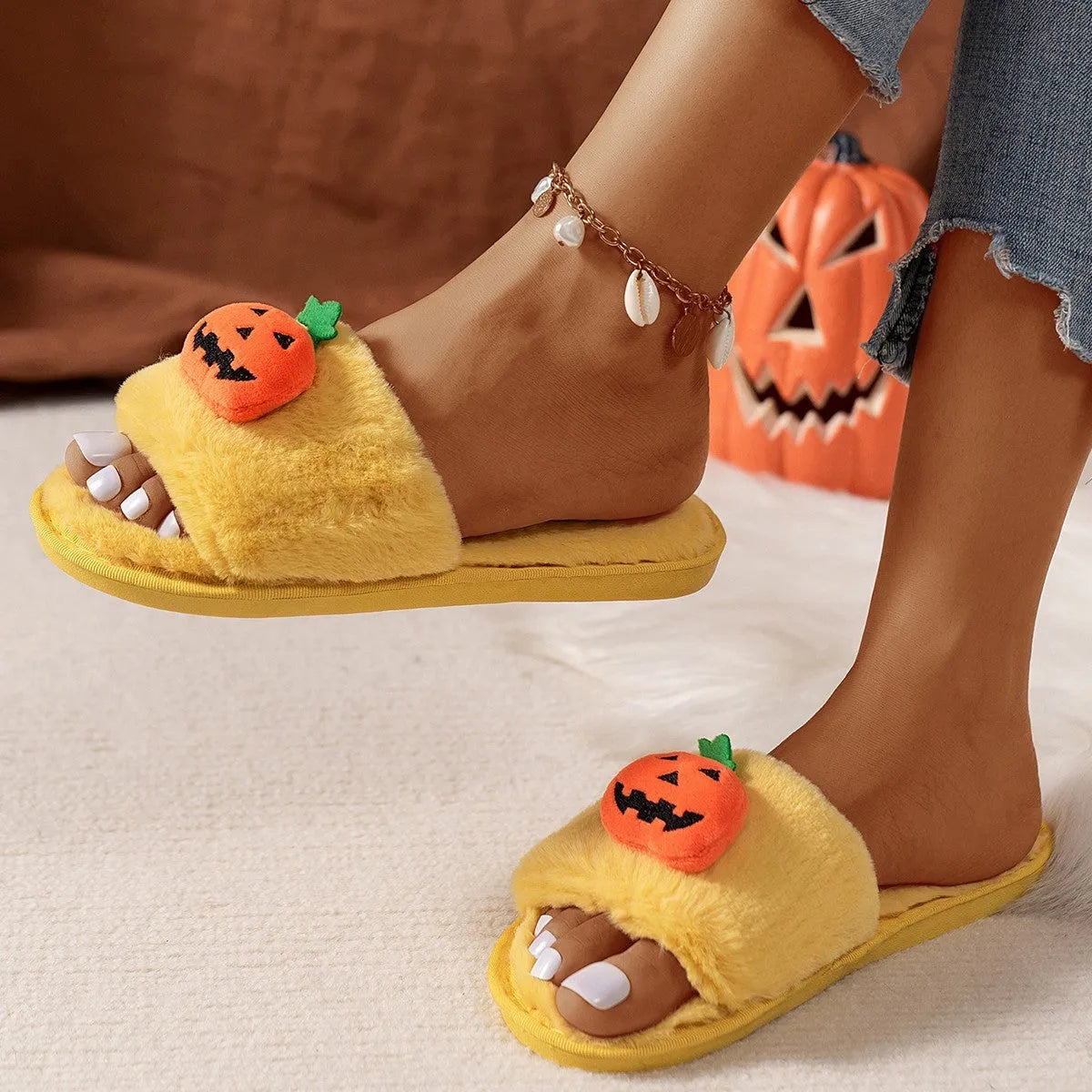 Yellow and white Halloween pumpkin cartoon design plush slippers with an open toe and textured sole.