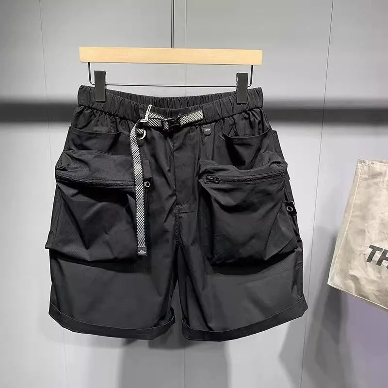 Men's loose-fit black work shorts with pockets, shown on a model, above the knee length.